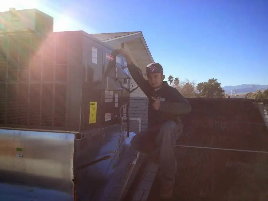 HVAC technician performing Boiler Repair on a rooftop unit in East Lake